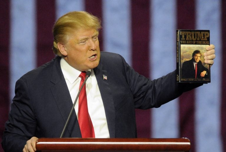 In this file photo, then-Republican presidential candidate Donald Trump holds up his book 'The Art of the Deal', given to him by a fan as he speaks during a campaign stop Saturday, Nov. 21, 2015 in Birmingham, Ala. (Eric Schultz/AP Photo)