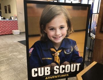 A poster at the entrance of the Laurel Highlands Council headquarters in Pittsburgh shows a young girl in a Cub Scouts uniform. The program for younger kids can include co-ed troops, but older kids will have single-sex troops. (Katie Blackley/WESA)