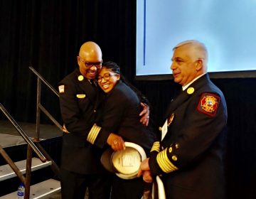 Ardavia Lee, daughter of a fallen Wilmington firefighter, is embraced by members of the fire department after receiving a $25,000 scholarship. (Zoe Read/WHYY)