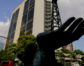 A sculpture of an oil pump held by a human hand stands outside the headquarters of Venezuela’s state-owned oil company. (Fernando Llano/AP Photo)