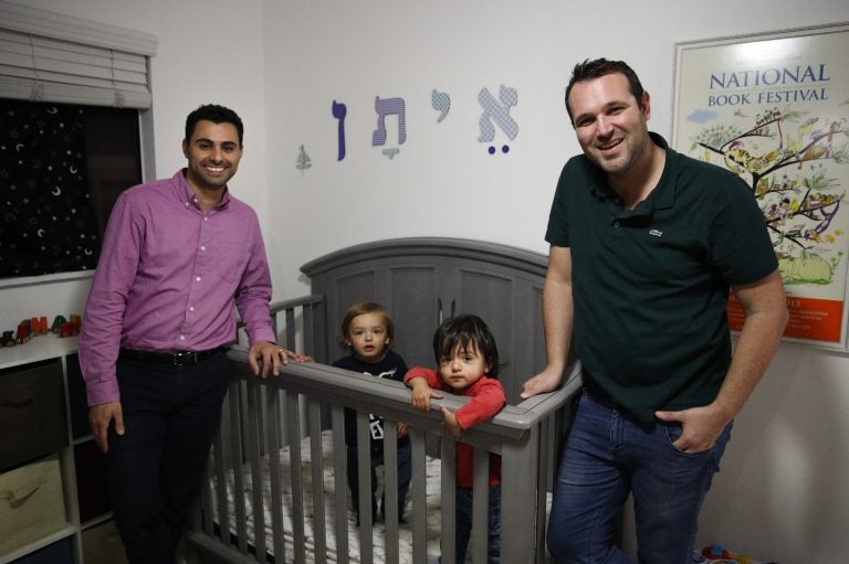 Elad Dvash-Banks (left) and his husband, Andrew, pose for photos with their twin sons, Ethan (center right), and Aiden in their apartment last year in Los Angeles. (Jae C. Hong/AP)