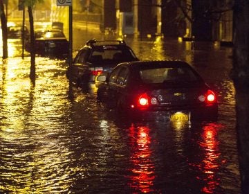 Vehicles sit in high floodwater during a storm surge associated with Superstorm Sandy in 2012, near the Brooklyn Battery Tunnel in New York. (John Minchillo/AP)