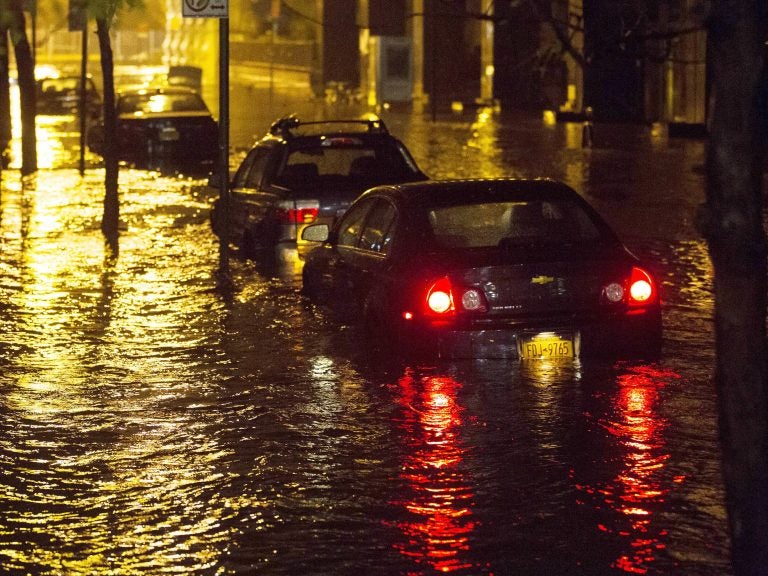 Vehicles sit in high floodwater during a storm surge associated with Superstorm Sandy in 2012, near the Brooklyn Battery Tunnel in New York. (John Minchillo/AP)