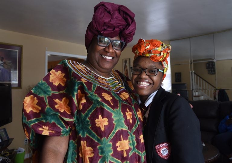 Geniah Miller in her Camden Academy Charter High School uniform and the Nigerian head wrap with her mother, Chioma Sullivan, at their Camden home on Feb. 11, 2019, after Miller was sent home from school. (April Saul for WHYY)