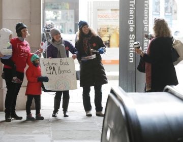 Environmental activists Liz Brandt (from left), with her daughters, Natalia, 3, and Valencia Bednar, 5; Martha Roberts; and Molly Rauch pose for a photograph while welcoming Environmental Protection Agency employees back to work on Jan. 28 in Washington, D.C. Furloughed employees returned to work following the end of the longest-ever partial federal government shutdown. (Chip Somodevilla/Getty Images)