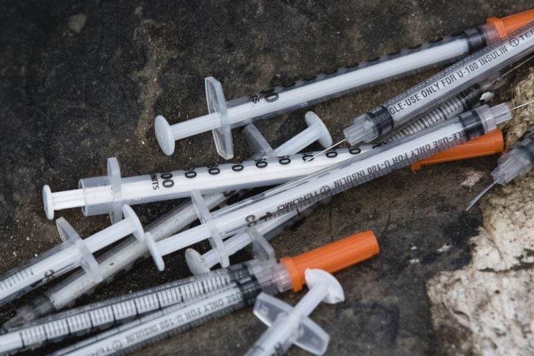 Discarded syringes lay near near train tracks in Philadelphia, Monday, July 31, 2017