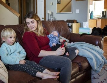 Amber Gorrow and her daughter, Eleanor, 3, pick out a show to watch after Eleanor's nap at their home in Vancouver, Wash., on Wednesday. Eleanor has gotten her first measles vaccine, but Gorrow's son, Leon, 8 weeks, is still too young to be immunized. (Alisha Jucevic/Getty Images)