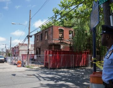 A police officer secures the block as investigators survey a demolition site that turned deadly at the corner of Jefferson and Bailey Streets in North Philadelphia on June 04, 2018.  (Lindsay Lazarski/WHYY)