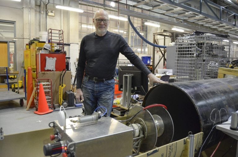 Red Whittaker stands beside an early prototype of RadPiper, a pipe-crawling robot that will help decommission uranium enrichment facilities in Ohio and Kentucky. Whittaker has worked in robotics for four decades at Carnegie Mellon University, and he developed several robots in the 1980s that helped clean up after the Three Mile Island incident. (Amy Sisk/StateImpact Pennsylvania)