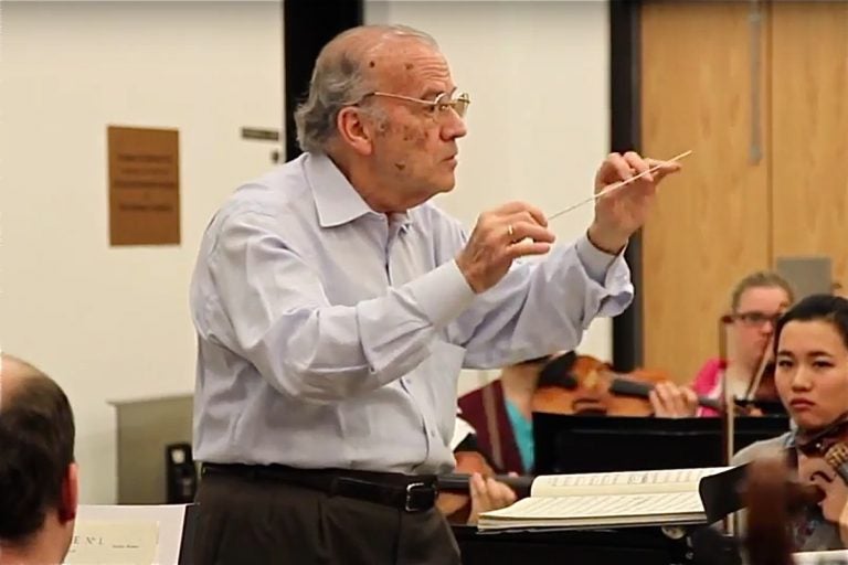 Temple music professor and orchestra conductor Luis Biava irehearses with the Temple University Symphony Orchestra on March 20, 2014, shortly before his retirement.  (Kimberly Paynter/WHYY)