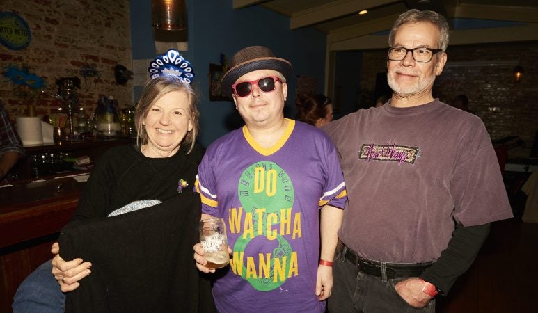 New Orleans natives Jan Marvin, Chris Marsceill, and Jeff Marvin celebrate Mardi Gras at the Acadia Bar in South Philadelphia. (Natalie Piserchio for WHYY)