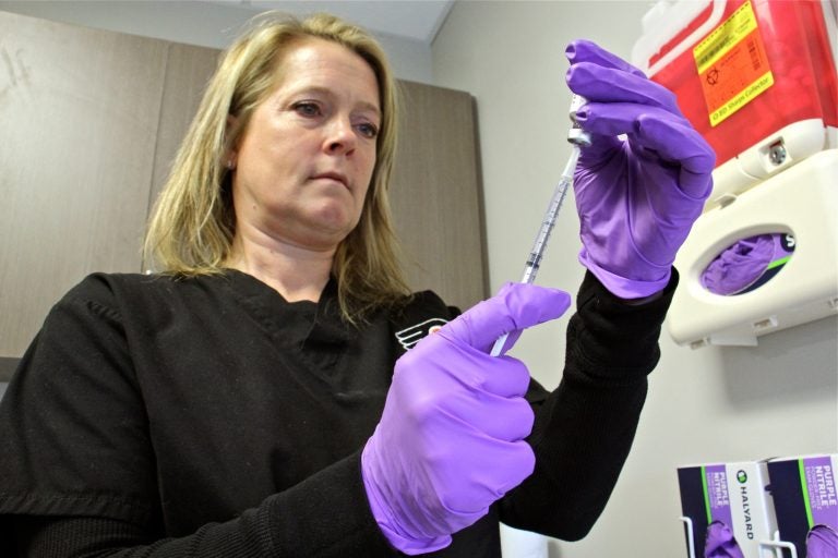 Registered nurse Nicole Rodriguez draws a dose of mumps vaccine at the Temple student health center. (Emma Lee/WHYY)