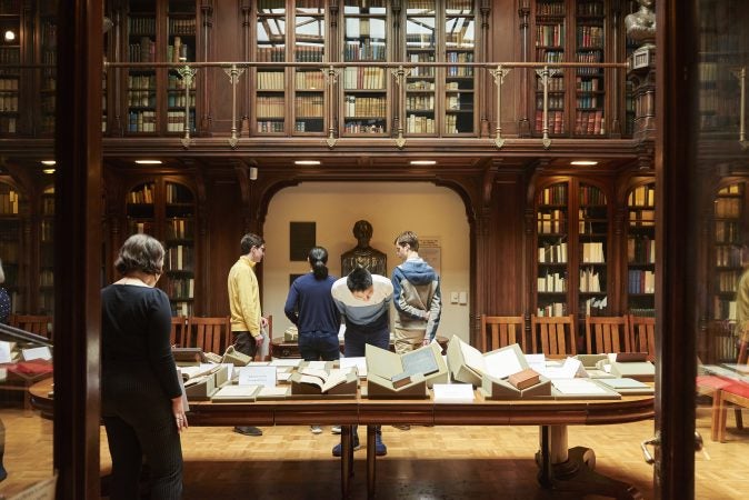 People gather to view a pop-up exhibit of drawings, photographs, manuscripts, books, and writings at Whitman at 200: Looking Back, Looking Forward a Symposium at the University of Pennsylvania in the Class of 1978 Orrery Pavilion, Van Pelt-Dietrich Library. (Natalie Piserchio for WHYY)