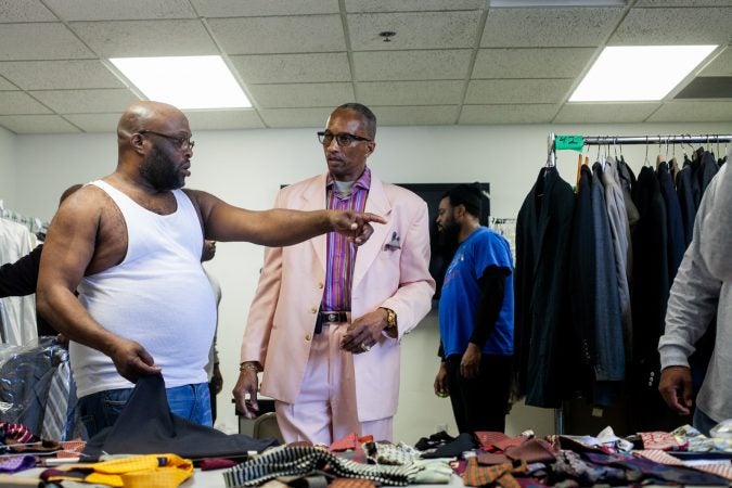 George Stevenson, a member of Enon Tabernacle, helps men pick out suits and offers advice on style. (Brad Larrison for WHYY)