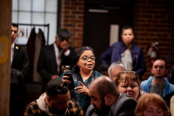 Kensington resident Rosalind Lopez reads statistics off of her phone that she had compiled in opposition to a proposed supervised injection site during a meeting on the city's efforts to combat the opioid epidemic. (Brad Larrison for WHYY)