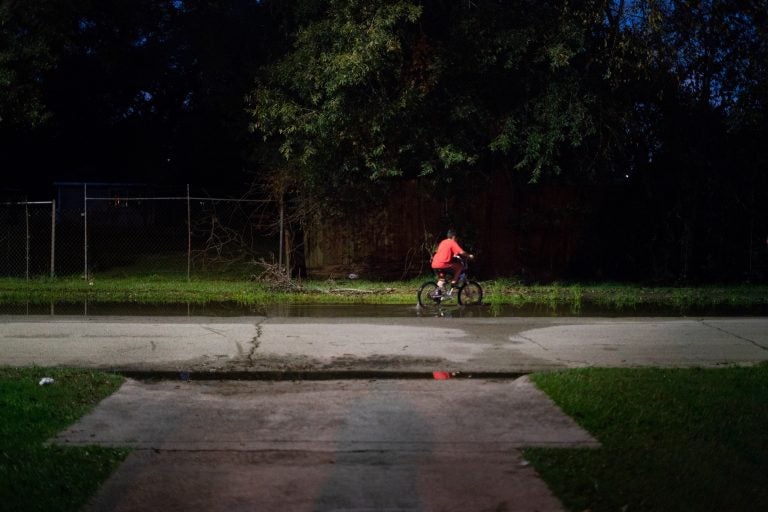 A boy rides his bike through still water after a thunderstorm in the Lakewood area of East Houston, which flooded during Hurricane Harvey.
(Claire Harbage/NPR)