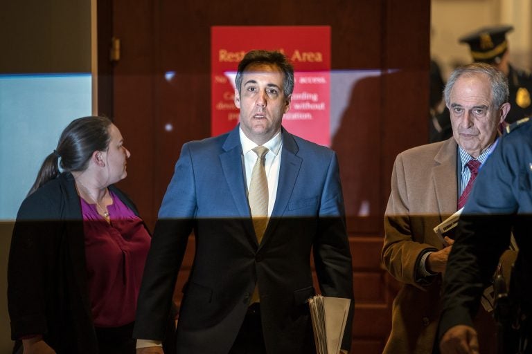 Michael Cohen, President Donald Trump's former lawyer, is illuminated by a camera flash as he leaves a closed-door interview with his attorney Lanny Davis, (right), after testifying before the House Intelligence Committee, on Capitol Hill in Washington, Thursday, Feb. 28, 2019. (J. Scott Applewhite/AP Photo)