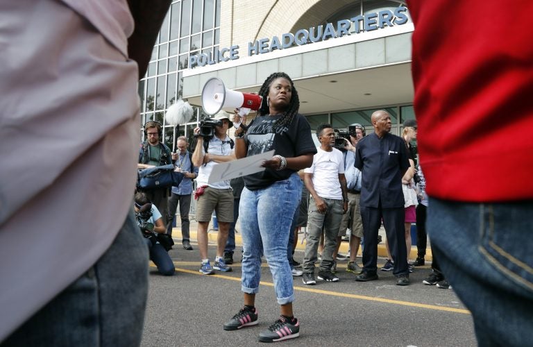 In this Sept. 17, 2017 file photo, Cori Bush speaks on a bullhorn to protesters outside the St. Louis Police Department headquarters in St. Louis. Six deaths, all involving men with connections to protests in Ferguson, Missouri, drew attention on social media and speculation in the activist community that something sinister was at play. Bush said her car has been run off the road, her home has been vandalized, and in 2014 someone shot a bullet into her car, narrowly missing her daughter, who was 13 at the time. Activists and observers remain puzzled, especially since people involved in the protests continue to face harassment and threats. (Jeff Roberson/AP Photo)