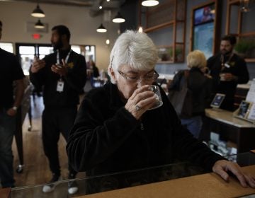 In this Feb. 19, 2019 photo, Sandy Sopher, 65, smells cannabis buds at Bud and Bloom cannabis dispensary in Santa Ana, Calif. As legal cannabis has spread to dozens of states, more Americans in their 70s and 80s are adding marijuana to the roster of senior activities such as golf and bingo. (AP Photo/Jae C. Hong)