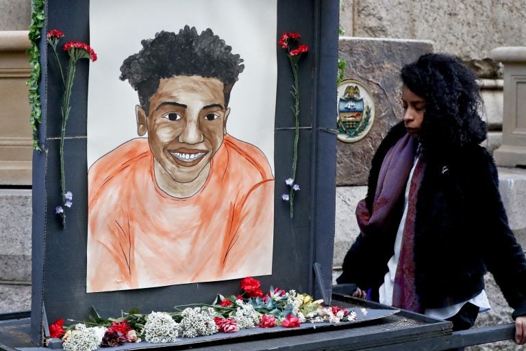 A woman who did not want to be identified holds a memorial display with a drawing of Antwon Rose II in front of the court house on the first day of the trial for Michael Rosfeld, a former police officer in East Pittsburgh, last month. Rosfeld was acquitted in the fatal shooting of Antwon Rose II as he fled during a traffic stop on June 19, 2018. (Keith Srakocic/AP Photo)