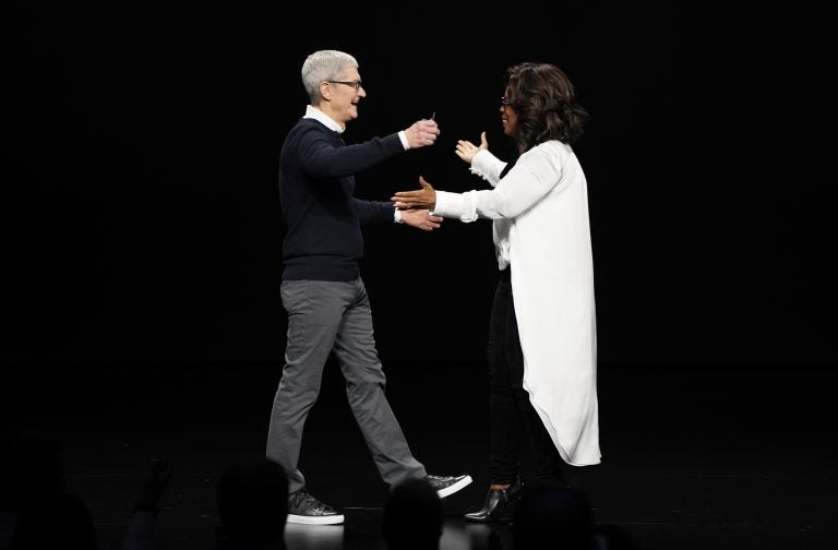 Apple CEO Tim Cook and Oprah Winfrey prepare to embrace at the Steve Jobs Theater during an event to announce new products Monday, March 25, 2019, in Cupertino, Calif. (Tony Avelar/AP Photo)