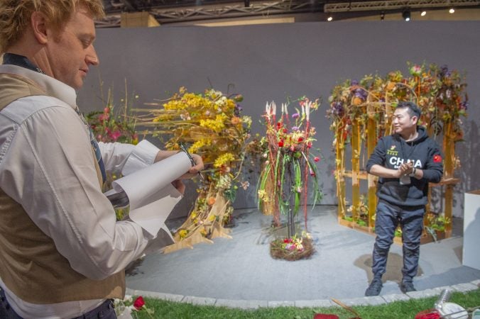 Judge Bjorn Kroner-Salie inspects the arrangement of China's Wei Yao at the conclusion of the semi-final round of competition. (Jonathan Wilson for WHYY)