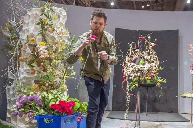 Stephan Tirbe, semi-finalist from Germany, inspect flowers at the start of the semi-final round of competition. (Jonathan Wilson for WHYY)