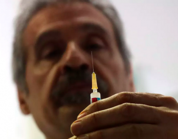 Dr. Roberto Ieraci prepares to vaccinate a child in Rome on Feb. 23, 2018. (Alessandro Tarantino/AP Photo)