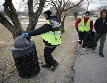 Malcolm Flowers (left) checks a trash can as Cristina 