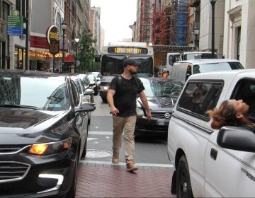 A pedestrian threads his way through snarled traffic at Broad and Chestnut streets. (Emma Lee/WHYY)
