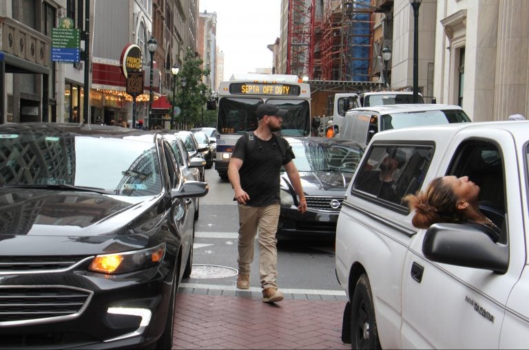 A pedestrian threads his way through snarled traffic at Broad and Chestnut streets. (Emma Lee/WHYY)