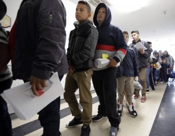 A line of migrants released by U.S. immigration authorities waits to check in at the Catholic Charities shelter in McAllen, Texas on Jan. 11. (Eric Gay/AP Photo)