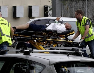Ambulance staff take a man from outside a mosque in central Christchurch, New Zealand on Friday. Multiple people are in custody after shootings at two mosques there. (Mark Baker/AP)