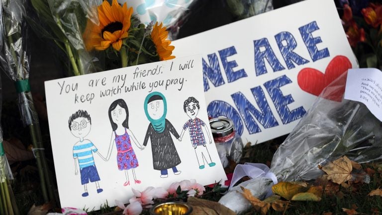 A message card is placed at a collection of flowers left at the Botanical Gardens in Christchurch, New Zealand, on Saturday. A 28-year-old white supremacist stood silently before a judge, accused in mass shootings at two mosques that left dozens of people dead. (Vincent Thian/AP Photo)