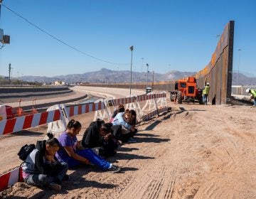 Salvadoran migrants wait for transportation after turning themselves in to U.S. Border Patrol agents in El Paso, Texas — where a border fence is under construction. The Pentagon says it will spend up to $1 billion to help build the fence. (Paul Ratje /AFP/Getty Images)