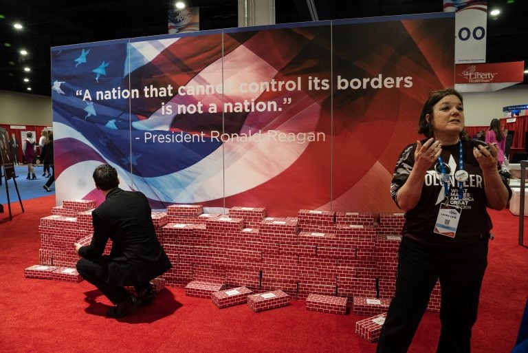A fake wall, made of cardboard bricks, is on display with a quote by former president Ronald Reagan that reads: 