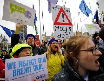 Anti-Brexit activists hold placards and wave flags as they demonstrate outside the Houses of Parliament in London on Tuesday, ahead of a crucial vote on Prime Minister Theresa May's Brexit deal. (Tolga Akmen/AFP/Getty Images)
