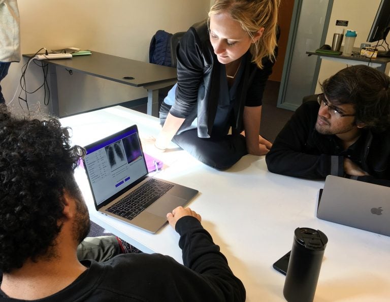 Amir Kiani (from left), Chloe O'Connell and Nishit Asnani troubleshoot an algorithm to diagnose tuberculosis in computer lab at Stanford University.
(Richard Harris/NPR)