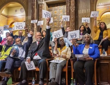 Candidates hold yes signs aloft signaling their agreement with the proposal of a representative speaker. Twenty candidates for city council attended a candidates forum at Congregation Rodeph Shalom on March 24, 2019. (Jonathan Wilson for WHYY)