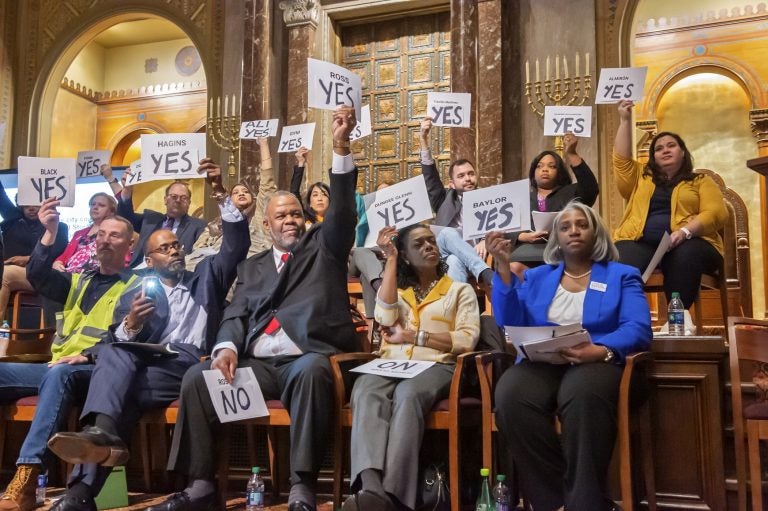 Candidates hold yes signs aloft signaling their agreement with the proposal of a representative speaker. Twenty candidates for city council attended a candidates forum at Congregation Rodeph Shalom on March 24, 2019. (Jonathan Wilson for WHYY)