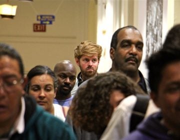 PlanPhilly reporter Ryan Briggs (center) waits in line at City Hall with other Philadelphians to get a city ID. (Emma Lee/WHYY)