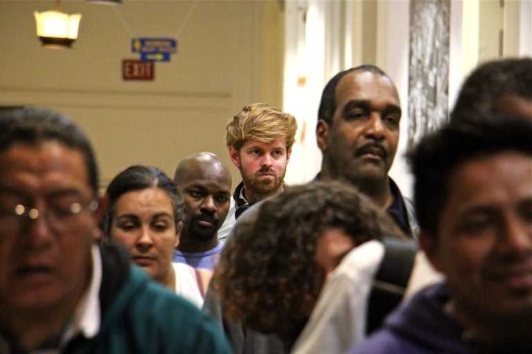 PlanPhilly reporter Ryan Briggs (center) waits in line at City Hall with other Philadelphians to get a city ID. (Emma Lee/WHYY)