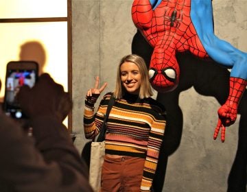 A visitor to the Franklin Institute's Marvel Comics exhibit poses for a photo with a life-size Spider-Man figure. The exhibit promises to be a crowd pleaser, with a quarter million visitors expected through the summer. (Emma Lee/WHYY)