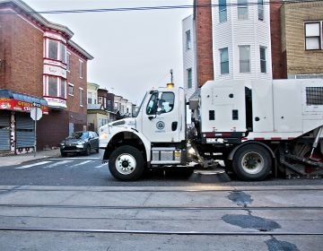 A city street sweeper cleans Chester Avenue in Southwest Philadelphia. (Kimberly Paynter/WHYY)