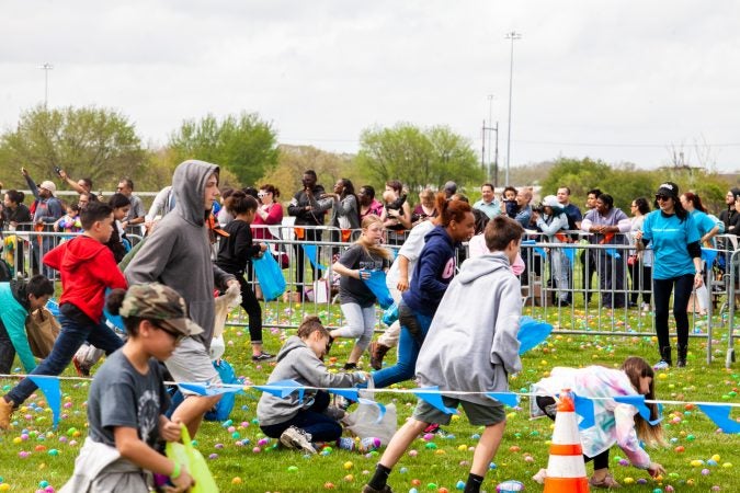 Following the Easter Egg drop children and some adults ran to collect them at the River Fields in Northeast Philadelphia. (Brad Larrison for WHYY)