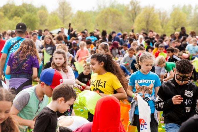 Following the Easter Egg drop children and some adults ran to collect them at the River Fields in Northeast Philadelphia. (Brad Larrison for WHYY)