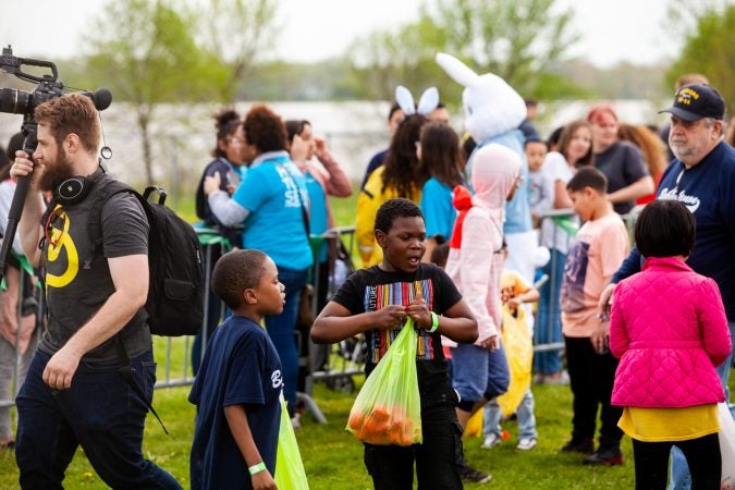 Children with their hall of Easter eggs at the River Fields in Northeast Philadelphia Saturday after a helicopter dropped an estimated 30,000 eggs. (Brad Larrison for WHYY)