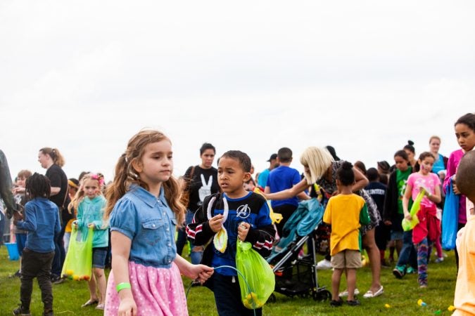 Children with their hall of Easter eggs at the River Fields in Northeast Philadelphia Saturday after a helicopter dropped an estimated 30,000 eggs. (Brad Larrison for WHYY)