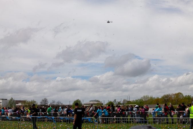 A helicopter containing a payload of an estimated 30,000 Easter eggs made its way toward the River Fields in Northeast Philadelphia Saturday. (Brad Larrison for WHYY)