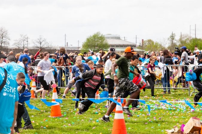 Following the Easter Egg drop children and some adults ran to collect them at the River Fields in Northeast Philadelphia. (Brad Larrison for WHYY)